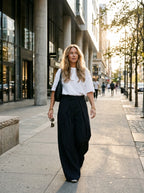 Navy pinstripe wide leg pants worn by a model on the street