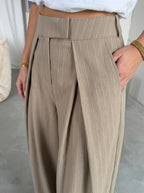 Pleated wide-leg trousers in pinstripe taupe, close-up of the front pleats